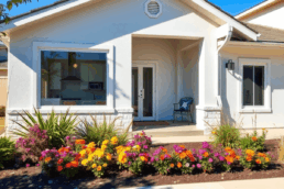 Bright modern home with landscaped yard, vibrant plants, large windows showing a stylish kitchen, and subtle smart lighting and security in a sunny...