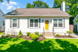 Bright suburban home with fresh exterior, neat front yard, and landscaping under clear sky, representing smart Midwest home renovation ideas.
